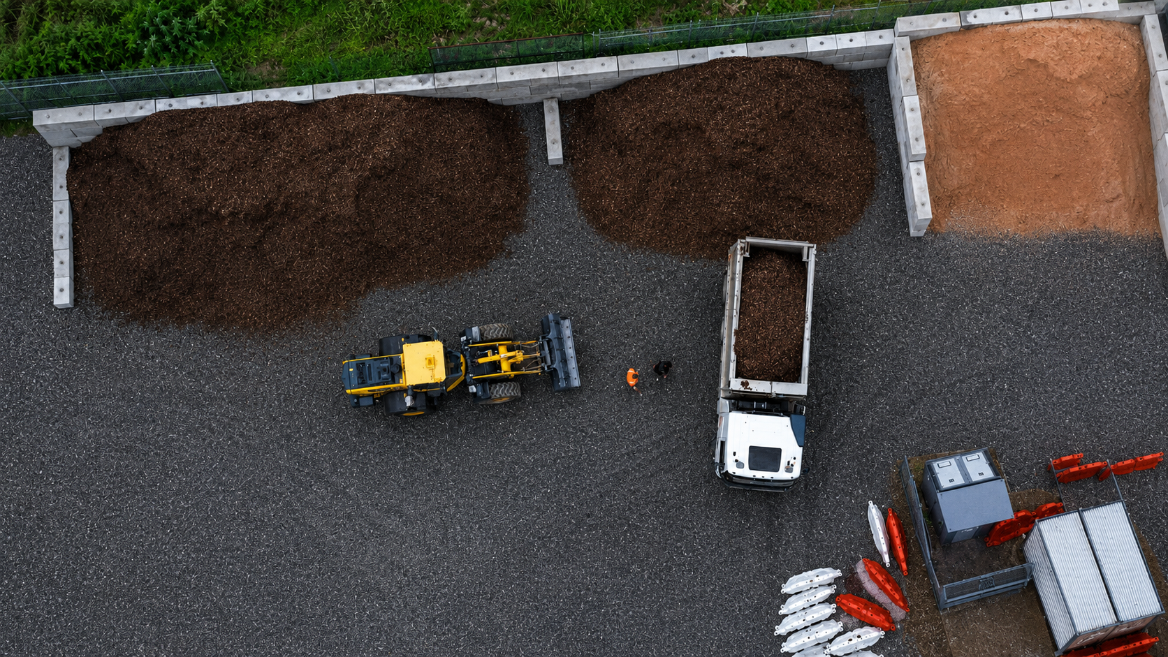 A loader filling a tip truck from the mulch bays at the Altona yard